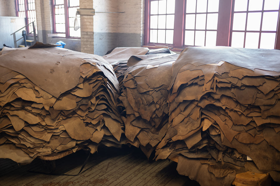 Piles of untanned horsehide sit in a factory awaiting colors to be applied.