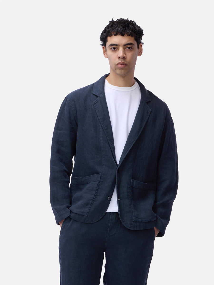 Man wearing a dark blue jacket and pants on a white background