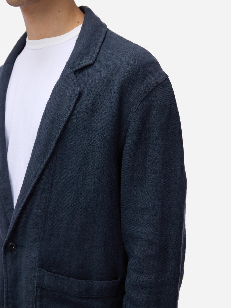 Navy blazer worn by a person on a white background